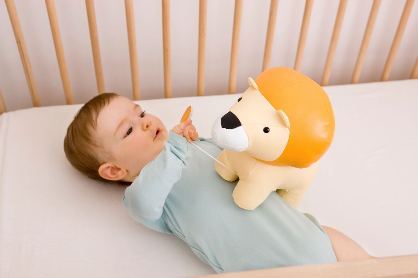 Criança a explorar com o tigre de pelúcia Little Big Friends. Criança a brincar com um tigre de pelúcia da marca Little Big Friends sobre um tapete colorido.